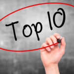 Man Hand writing Top 10 with black marker on visual screen. Isolated on grey. Business, technology, internet concept. Stock Photo